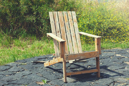 Wooden chair on the beach of a relaxing lake at sunrise