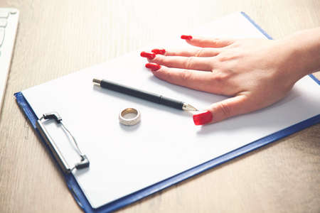 Hands of wife, husband signing decree of divorce, dissolution, canceling marriage, legal separation documents, filing divorce papers or premarital agreement prepared by lawyer. Wedding ringの写真素材