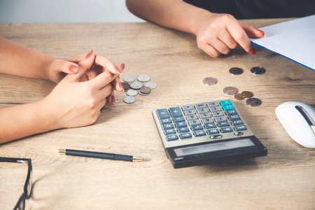 Accountants calculating profit close up shot of hands counting coinsの写真素材