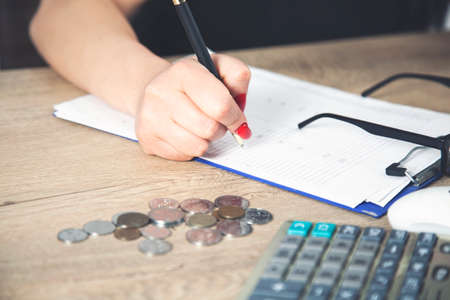 Accountants calculating profit close up shot of hands counting coins and making notes on paper