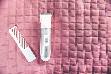 hairbrush and hair clipper isolated on pink background.