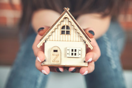 Woman's hands holding model house. Real estate concept.の写真素材