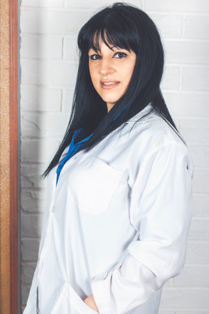Smiling woman doctor holding hands in pocket. isolated female portrait. Smiling medical woman doctor. Isolated over gray background. Cheerful happy doctor with crossed hands on gray backgroundの写真素材