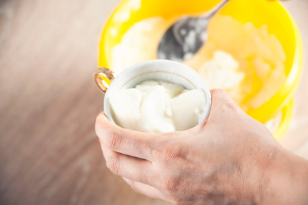 woman holding ice cream bowl filled with ice cream and scoop in other handの写真素材