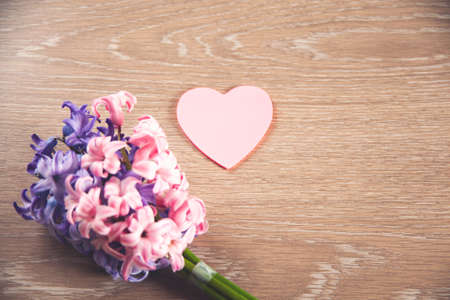 flowers and pink heart on a wooden tableの写真素材