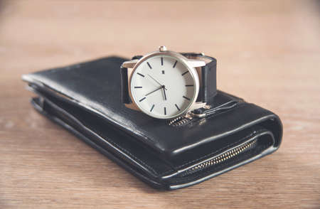 elegant watch and wallet on wooden tableの写真素材