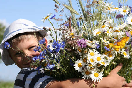 Child holding a bouquet of flowersの写真素材