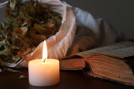 Things on table - a burning candle, a book, etc.