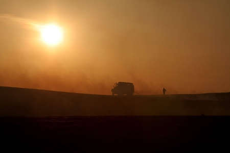 Fighting the fire at sunsetの写真素材