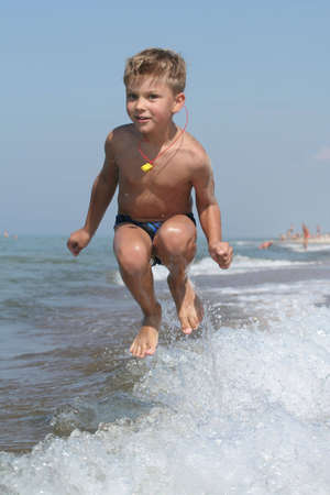 A child playing with waves at the beachの写真素材