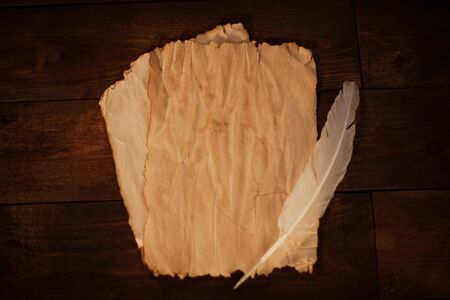 Quill for writing. Natural wooden table brown. An empty scroll of paper. Magic, occultism, mysticism.の写真素材