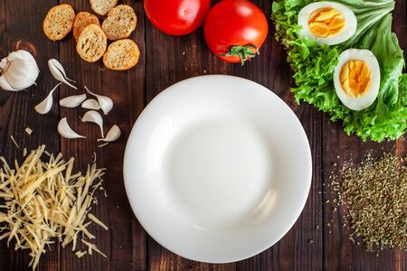 Instructions for the preparation of Caesar salad. Step one. We will need a plate, salad, fried or boiled chicken, eggs, tomatoes, cheese, crackers.の写真素材