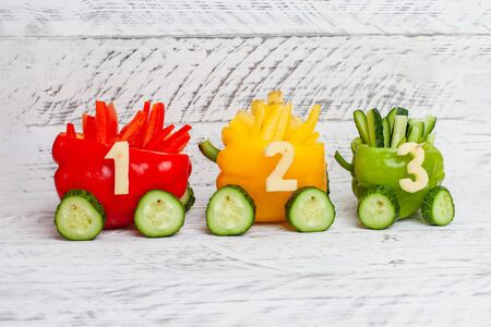 Multi-colored peppers. Red, yellow, green peppers as a traffic light. DIY educational toy for children on a white background. Children's train made of food with numbers.の写真素材