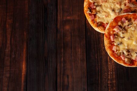 Homemade pizza on a wooden brown background. Delicious beautiful home-made pizza. Empty space for text.の写真素材
