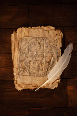 Magical writings, piles, aged paper, candles, wooden brown background Halloween celebrationの写真素材