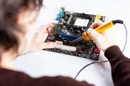 Technological background with closeup on tester checking motherboard. Toned image. Shallow DOF