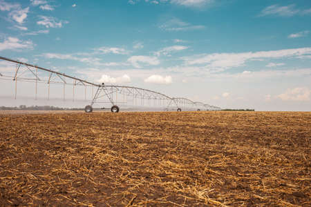 Moved irrigation system on a farmer's field. Field irrigation with a pivot sprinkler system. Watering plants with spray technology. Yield increase.の写真素材