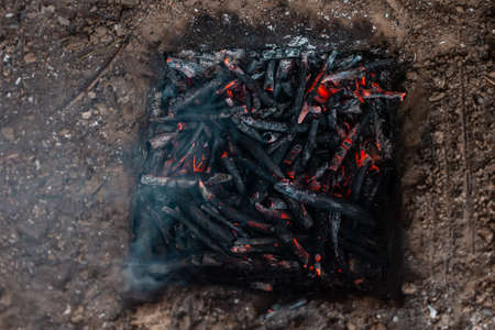Coals from a campfire in a sand pit. Fire.の写真素材