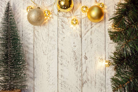 White wooden Christmas background. Empty space for text. Happy New Year. Small Christmas trees, garland with lights.の写真素材