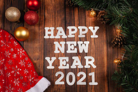 Christmas card, inscription with New Year 2021, wooden brown background, Christmas decorations,...