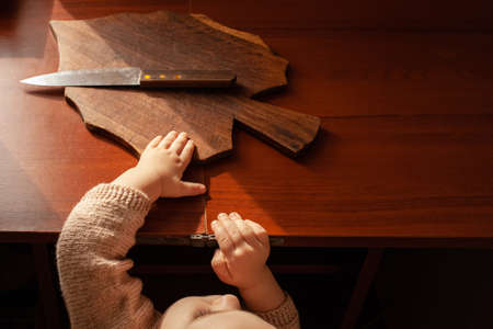 The child pulls a knife from the table, danger. The child can cut, children's home dangers. A little...