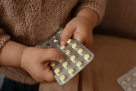 The child took out pills, the girl is playing with medical medicine, a one-year-old child can eat...