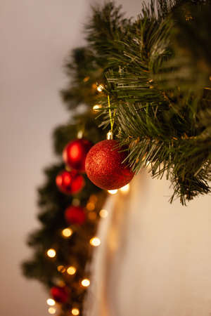Christmas photo zone, yellow lights, sideways. Red Christmas tree balls on the tree branch. New Year's wreath.の写真素材