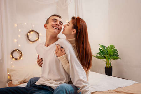 A young couple in love in a photo studio. Christmas scenery, guy and girl love each other. Posing...