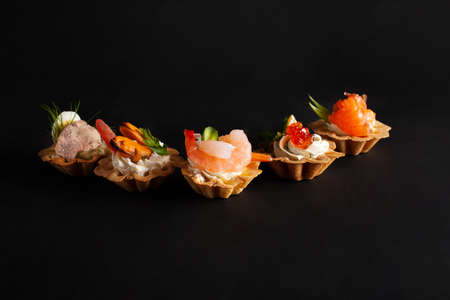 Seafood tartlets, studio photo. Shrimp salmon pate mussels, red caviar. Delicatessen. Gourmet food...