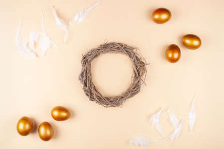 Empty space for text, a banner of happy Easter. Painted golden eggs, white feathers. copy space flat lay top view Nestの写真素材