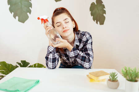 Eco-cleaning. A young woman loves eco goods For cleaning in the house. Green plants