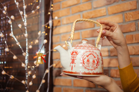 Moldova, Tiraspol, 01.15.2022 Teapot in tea shop, beautiful goods in womens hands. Chinese drawingのeditorial素材