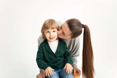 A happy family isolates on a white background, smiling, hugging, kissing. Concept, lifestyle. mother...