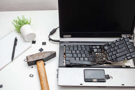 The man destroyed laptop with a hammer. Nervous work, buggy computer, errors, slow Internet, not saved in the game, printed text, hung. Bad old computer failed, does not turn on, hangs.の写真素材