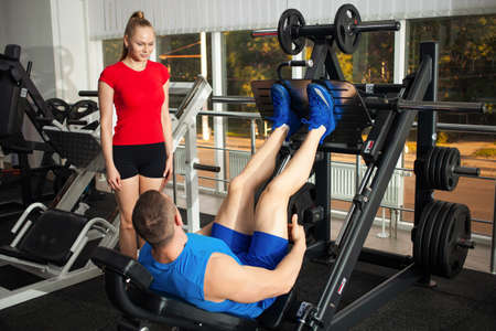 A teenage girl performs an exercise on a simulator in the gym. Weight loss, a healthy active sports...