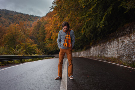 lonely man on road, concept of loneliness, depression, thoughtfulness. Autumn, mountains, beautiful background. Abstraction path to oneself, feeling of soul, cloudy bad weather.の写真素材