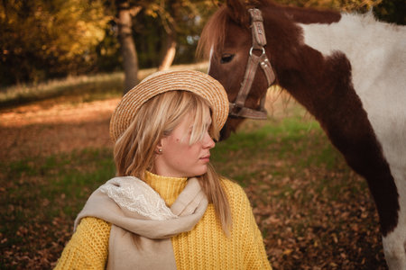 Beautiful picture, autumn nature, woman and horse, concept of love, friendship and care. background. unusual portraitの写真素材
