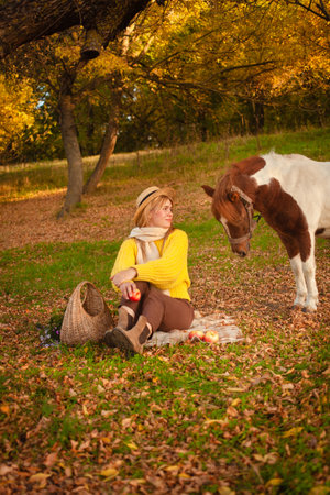 Beautiful picture, autumn nature, woman and horse, concept of love, friendship and care. background.の写真素材