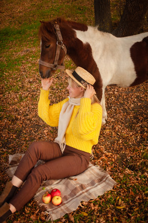 Beautiful picture, autumn nature, woman and horse, concept of love, friendship and care. background. plaidの写真素材