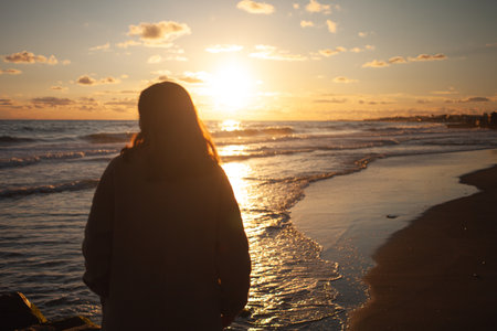 Sunset beach walk for serene womanの写真素材
