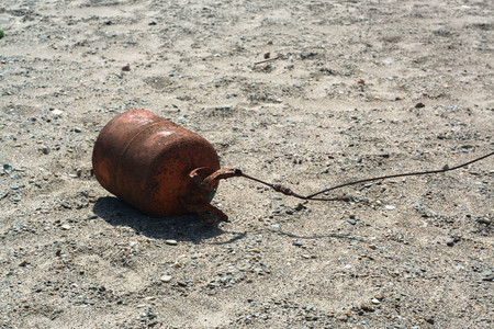 Old lonely rusty buoy on the sandの写真素材