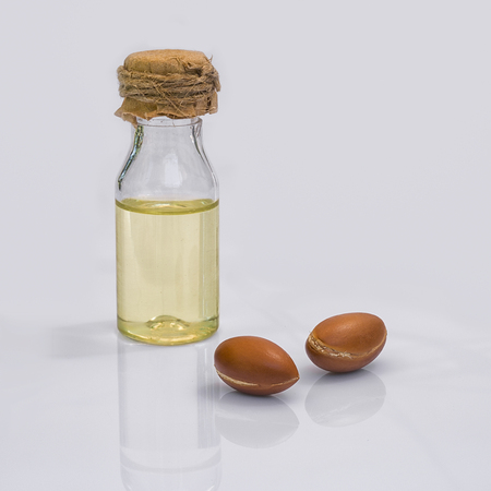 Argan fruit (Argania spinosa), nuts and oil on white background , this original seed of Morocco is used in cosmeticsの写真素材