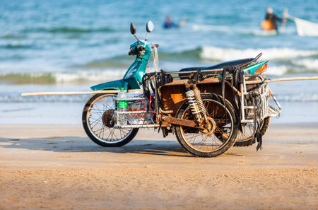 Fisherman park motorcycle on beach and fishig in the seaの写真素材