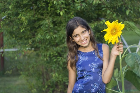 Girl with sunflower in gardenの写真素材