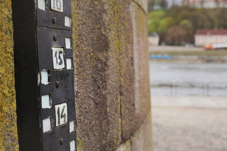 Hydrometric water level meter on old stone wall near riverの写真素材