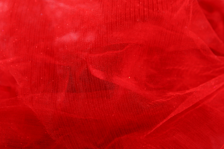Red tulle fabric background. Abstract transparent material curve wave.の写真素材