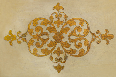 Vintage floral ornament.  Yellow ornament on old furniture surface.