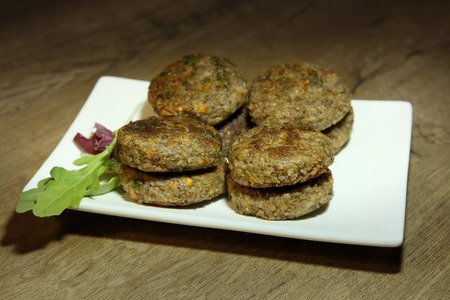 Buckwheat burgers in plate. Buckwheat burgers with carrots and parsley, vegan dish.