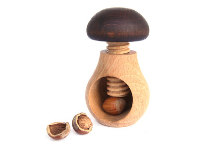 Wooden mushroom shape nutcracker isolated on white background. Screw type nut cracker with hazelnut.の写真素材