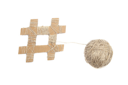Hashtag made from cardboard with thread ball isolated on white background. Hashtag sign with threads...